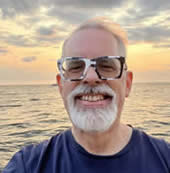 Man smiling in front of beach