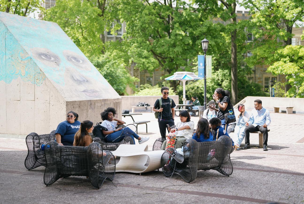 Student outside at Lehman sitting down