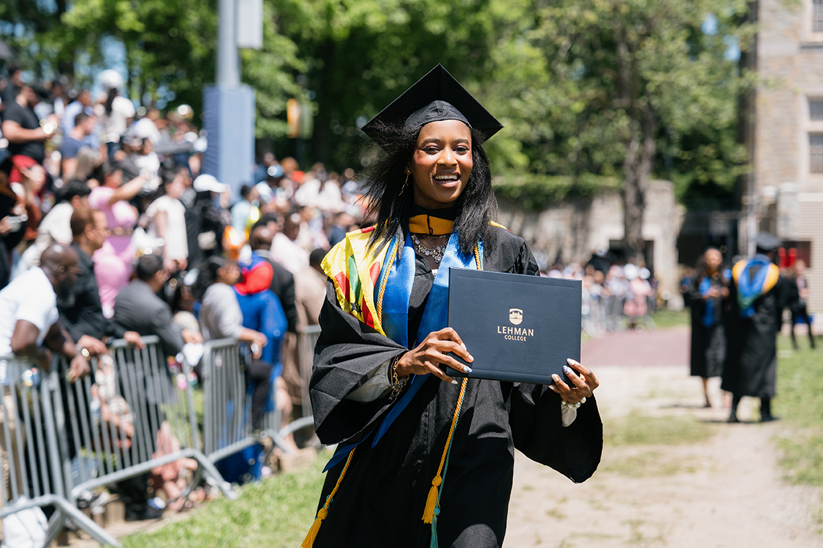 Photo of Graduate holding her diploma during graduation ceremony