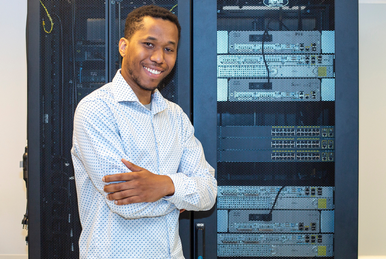 Photo of computer technician in front of computer servers