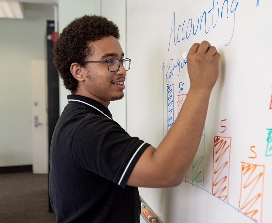 Photo of student writing on white board