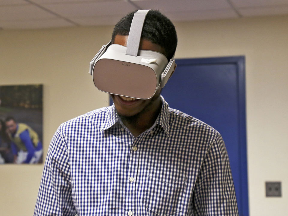 Photo of Lehman Student wearing VR goggles