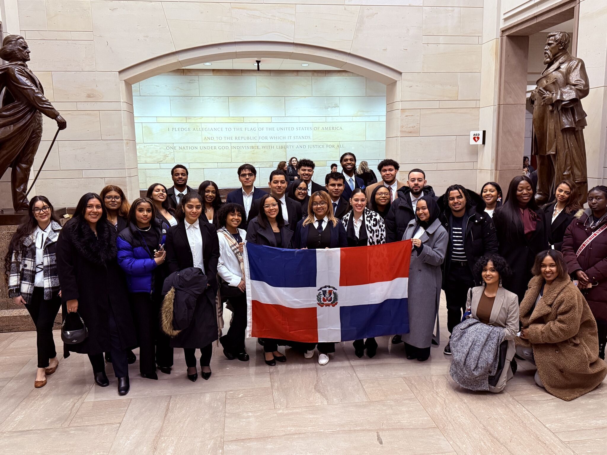 A group of students and faculty holding a Dominican flag inside the Capitol building.