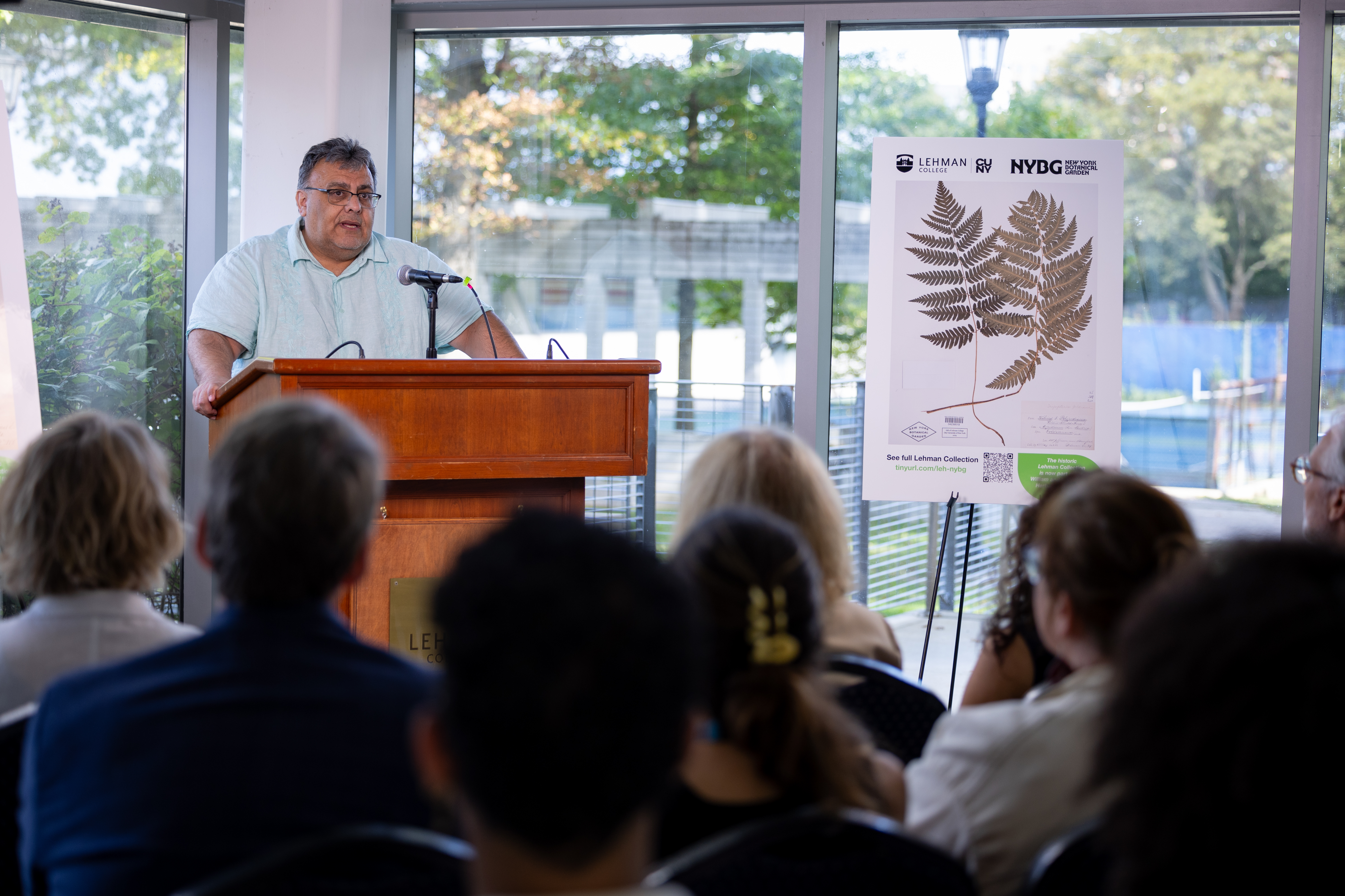 President Delgado speaks from a podium to a small audience