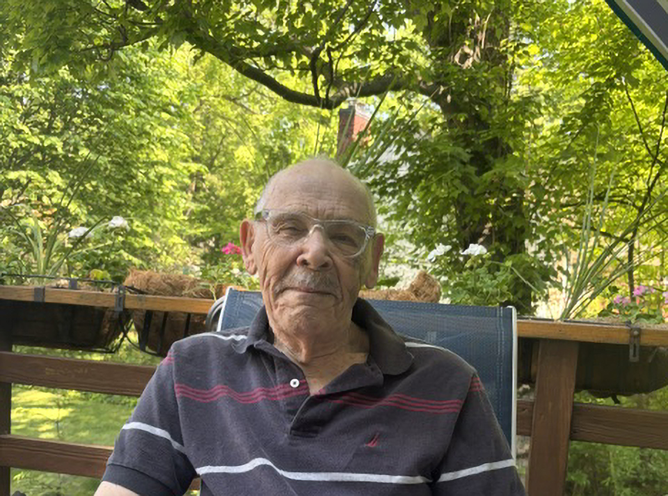 Edward Seldin seated on a deck.