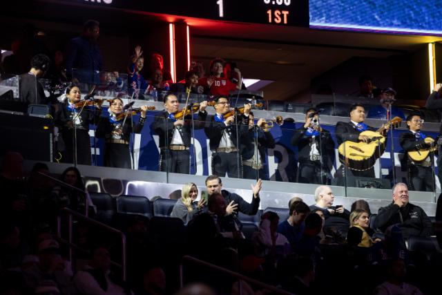 A mariachi band playing at a Madison Square Garden hockey game.