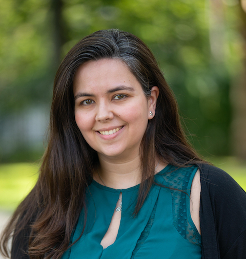 head shot of a woman with long dark hair and a green blouse.