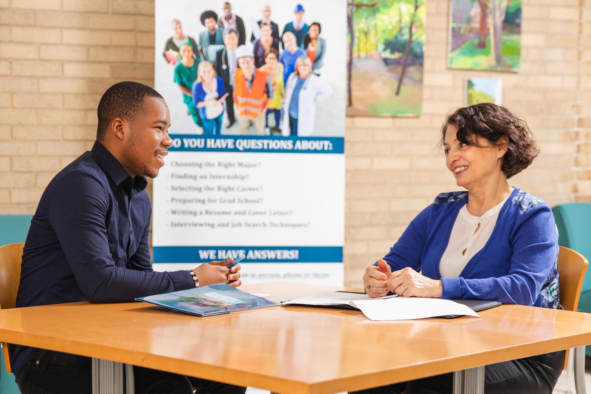 two people sitting and talking at a table