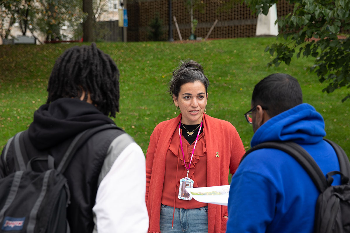 Staff member talking to two students