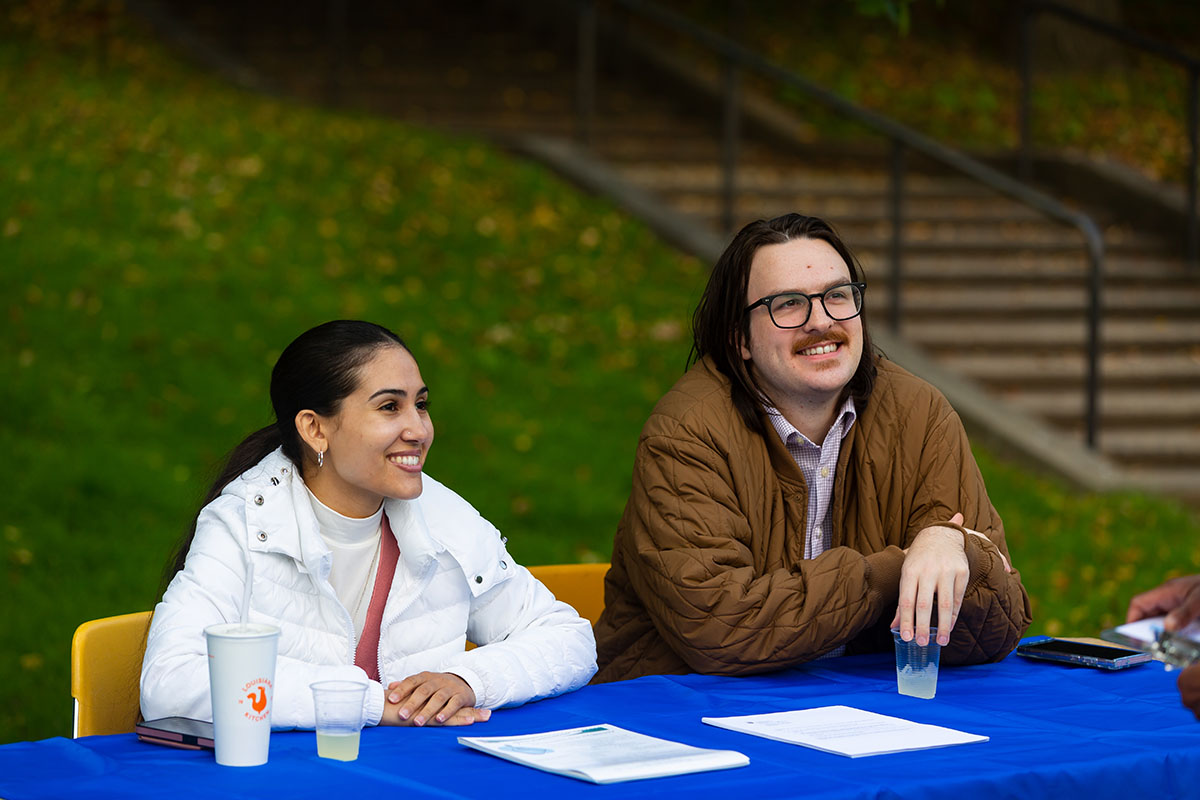 two staff members smiling